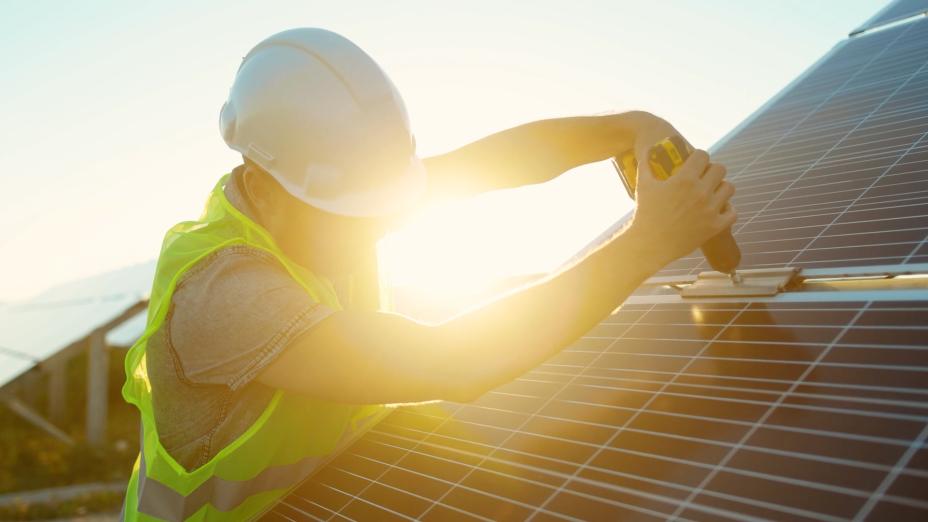 Homem instalando energia solar fotovoltaica.